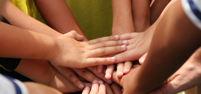 kids hands together in a group huddle