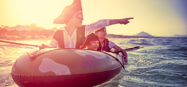 kids dressed as pirates on a rubber boat on water