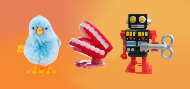 Three wind-up toys against an orange background