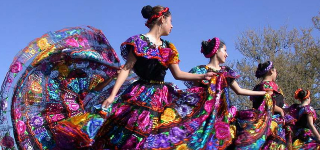 Four dancers perform the Mexican folk dance "baile folklórico" outdoors