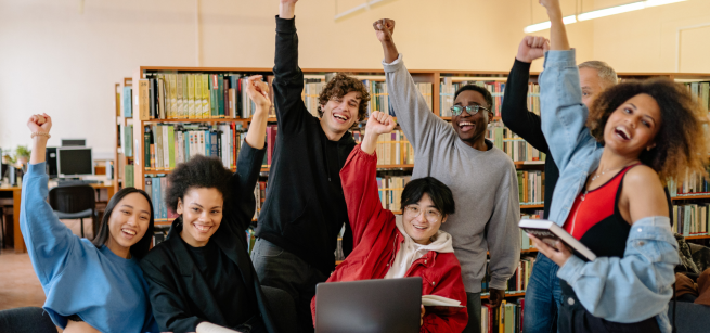 A group of teen students with their fists pumped in the air