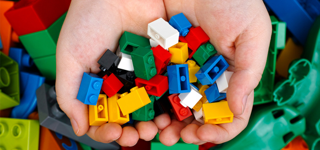 A child's hands holding toy building bricks.