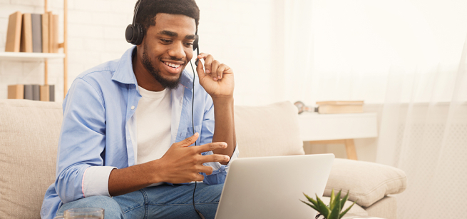 man wearing a headset while sitting in front of a laptop