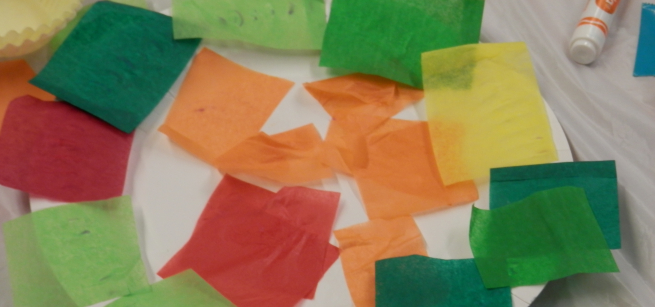 Paper plater with squares of colored tissue paper glued onto it.