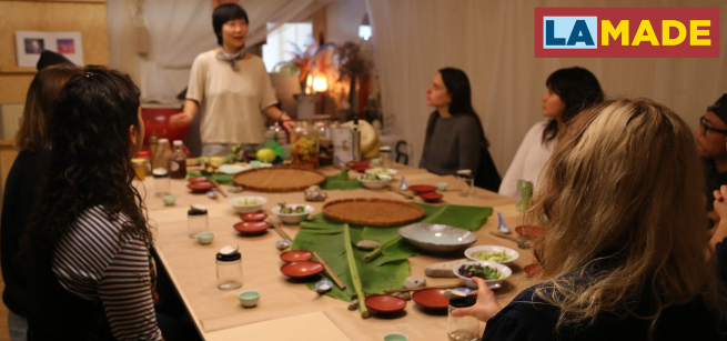 Chef Jess Wang speaking to people at the dinner table. 