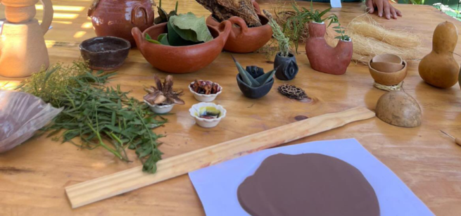 Clay is spread out on a table, along with dried flower petals and other textures that can be added to the clay
