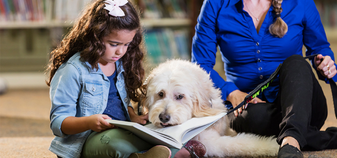 girl reading to a dog