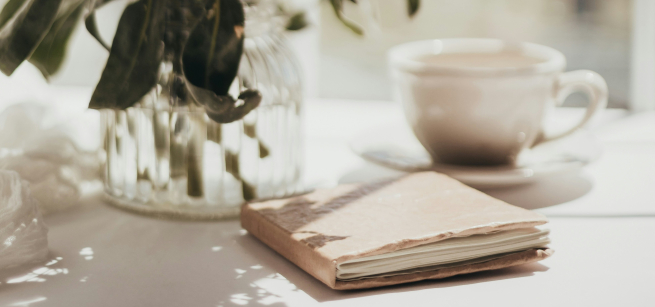 Soft journal beside coffee and flowers