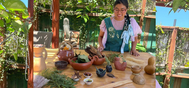 A woman sitting down with clay sculptures and plants surrounding her.