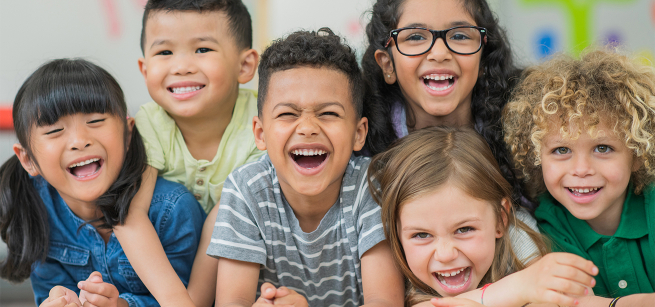 Six young children laughing.