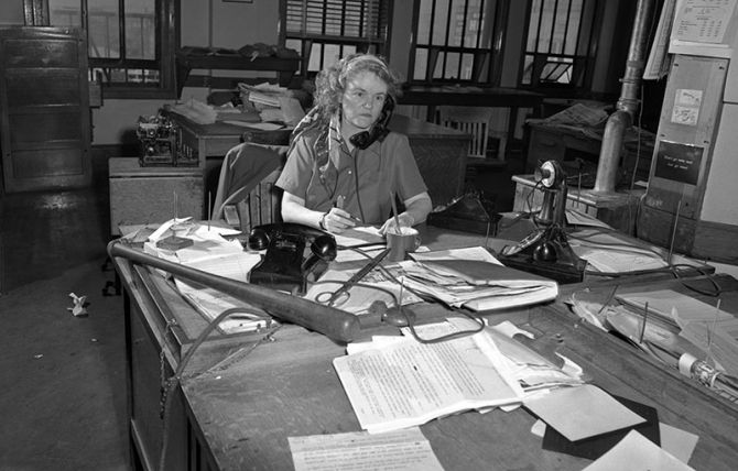 Agness "Aggie" Underwood at her desk in 1949, two years after becoming the city editor for the Los Angeles Herald and Express. She kept a baseball bat handy in case she needed to keep overzealous Hollywood press agents in line. 