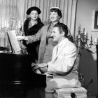 Liberace is shown with Miss Mildred Darby, left, and Mrs. Donald Huish, as they get in tune for Sherman Oaks Woman’s Club’s May 24 luncheon and fashioncade at the George Liberaces.  May 1956.