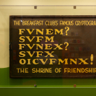 The Breakfast Club's Famous Cryptogram painted on a wooden block.