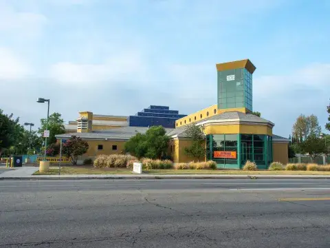 Mid-valley regional library, a green and yellow postmodern style building, with road in foreground.