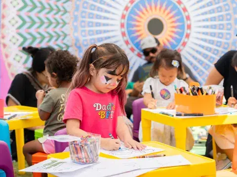face-painted child colors at yellow tables