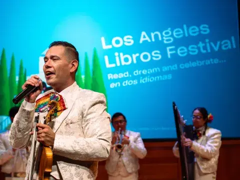 mariachi band performing in front of screen that reads "Los Angeles Libros Festival"