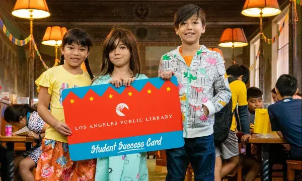 Kids holding up large student success card