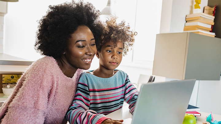 mother and child sitting in front a laptop