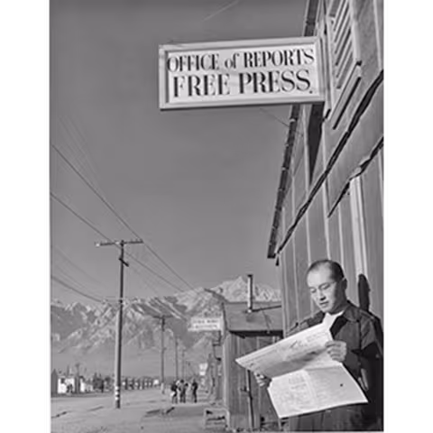 Editor Roy Takeno stands outside the newspaper office at the Manzanar Relocation Center in California, circa 1943.