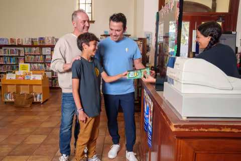 family checks out books at circulation desk