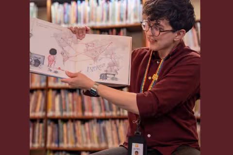 librarian holds up book in storytime