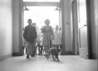 black and white photo of elementary school students entering school doors with cat