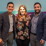 2 men and a woman smiling with their arms around each other