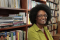 Harryette Mullen next to book shelves
