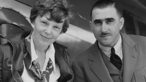 Amelia Earhart and technical expert Paul Mantz study the route Earhart undertook in a flight from the Hawaiian Islands to California, the longest over-water flight ever undertaken at that time.