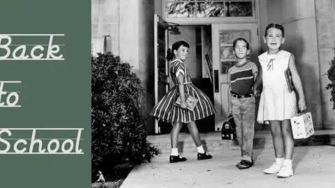 3 children heading into a school on the first day