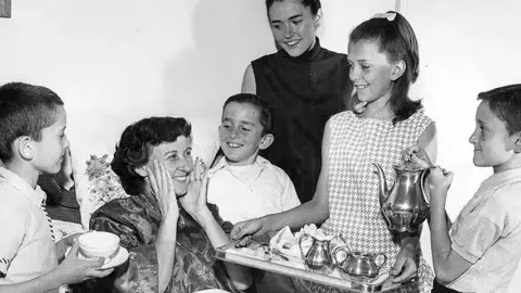 Mrs. Elwood Berney lying in bed with her children