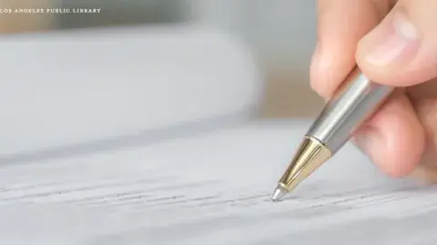hand holding pen filling out an application