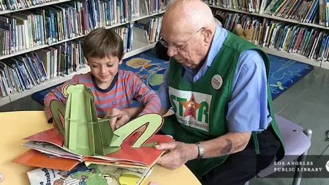 Senior reading to a child at the library