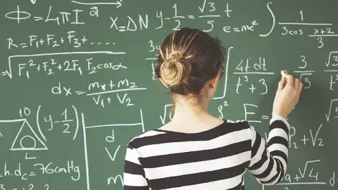 Girl solving a mathematical problem on the blackboard