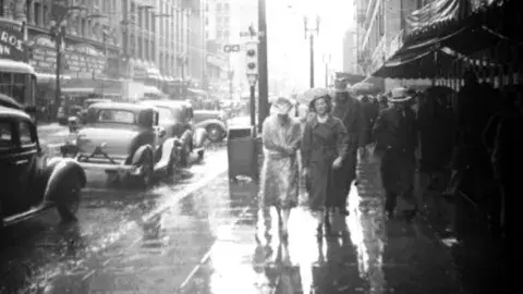 Walking in the rain by the Warner Downtown