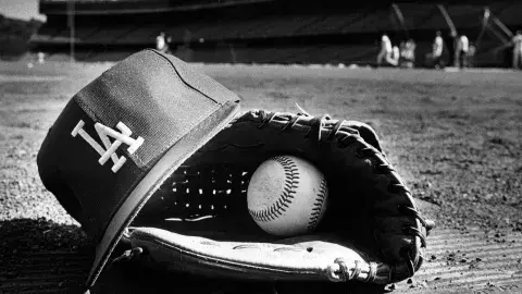 Close-up view of a Dodger player's hat, glove, and ball left on the field