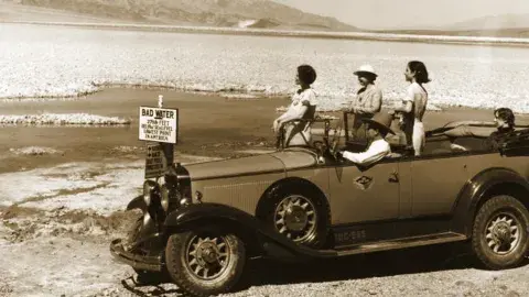 Tourists viewing Badwater in Death Valley from their car