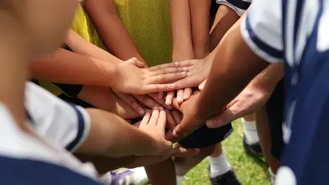 kids hands all together in a team circle
