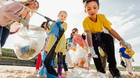 kids and parents clean up a beach
