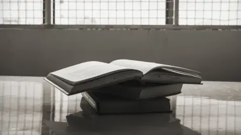 open stack of books on a table in prison