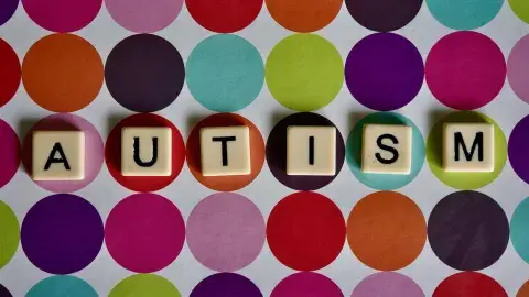 Scrabble tiles spelling out the word AUTISM