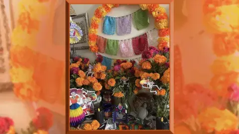 Altar con flores de cempasúchil, velas, y nicho