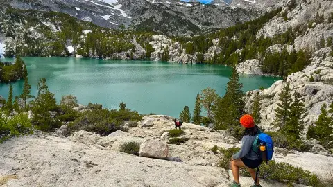hiker looking at a vista with a lake and mountains