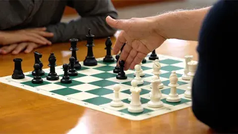 a chess board with two players actively playing a game of chess