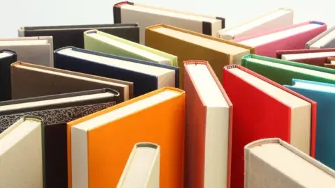 Books standing on end arranged randomly.