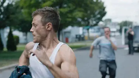 young man in tank top running away from another man