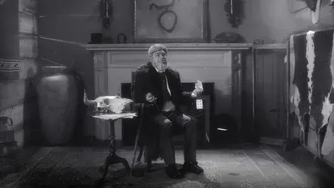 man sits on chair in front of fireplace