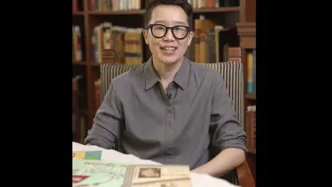 person sits behind table with various menus