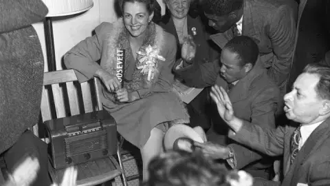 Helen Gahagan Douglas (center) sits around a radio with other supporters Franklin Delano Roosevelt