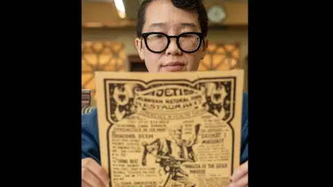 person reads vintage menu